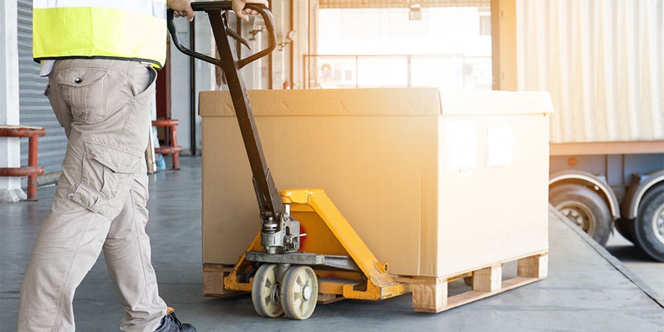 warehouse worker is working with hand pallet truck and shipment